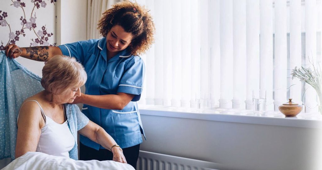 Carer helping client to get dressed