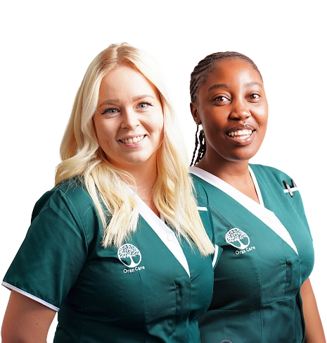 Two healthcare professionals in teal scrubs smiling at the camera.